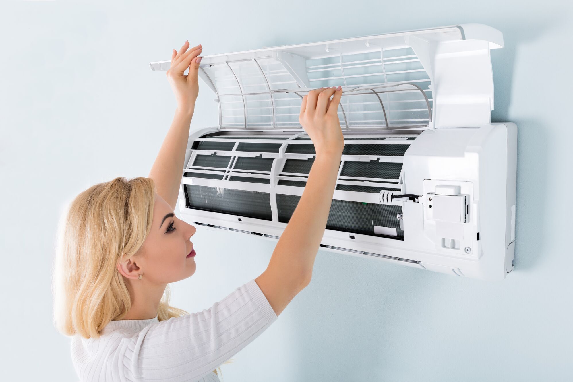 A woman technician repairing the AC