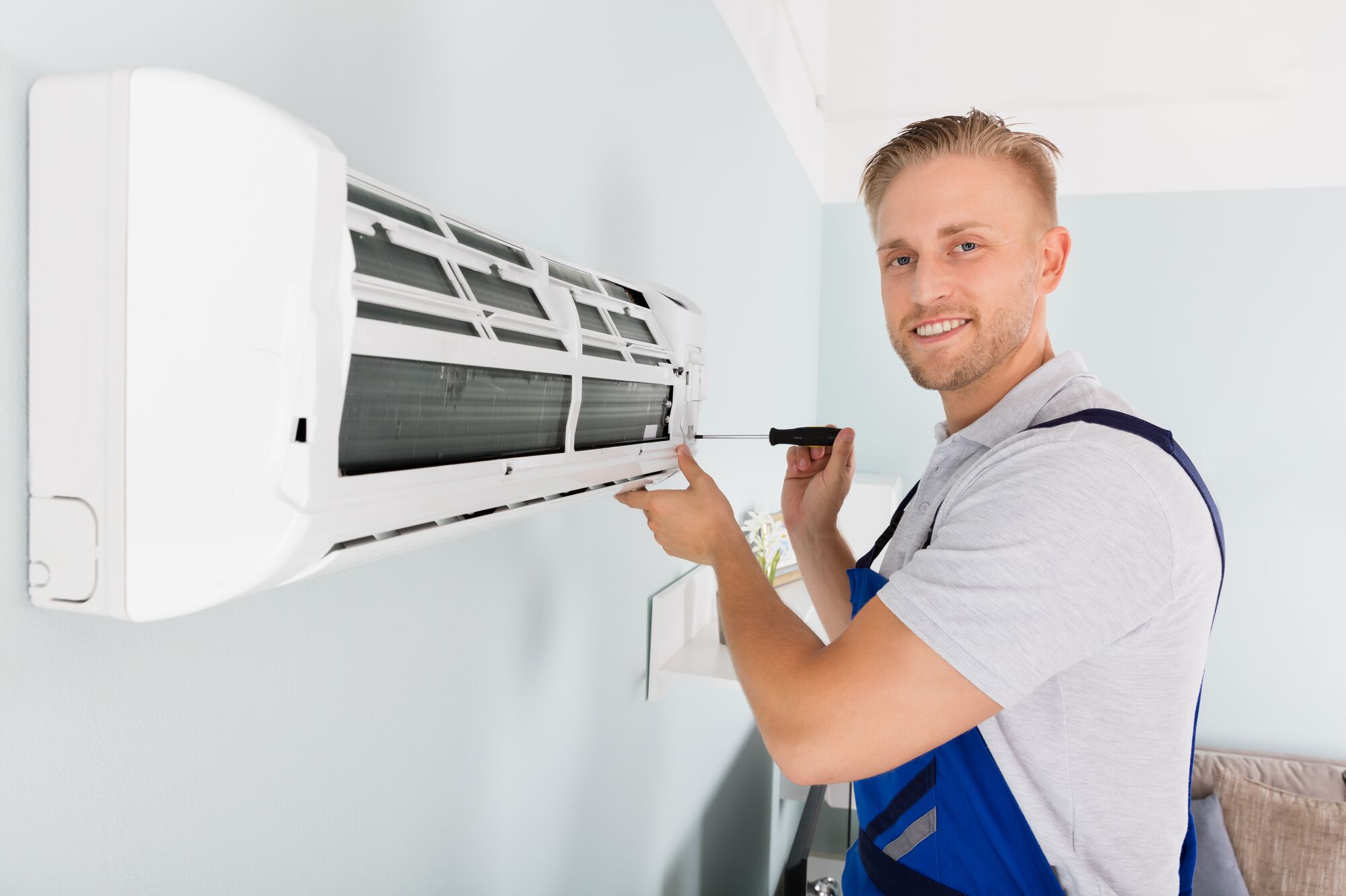 Student smiling while repairing an HVAC machine