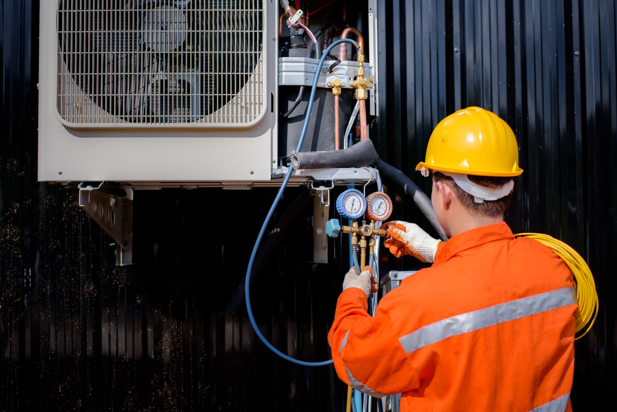 Man measuring the machine of a HVAC